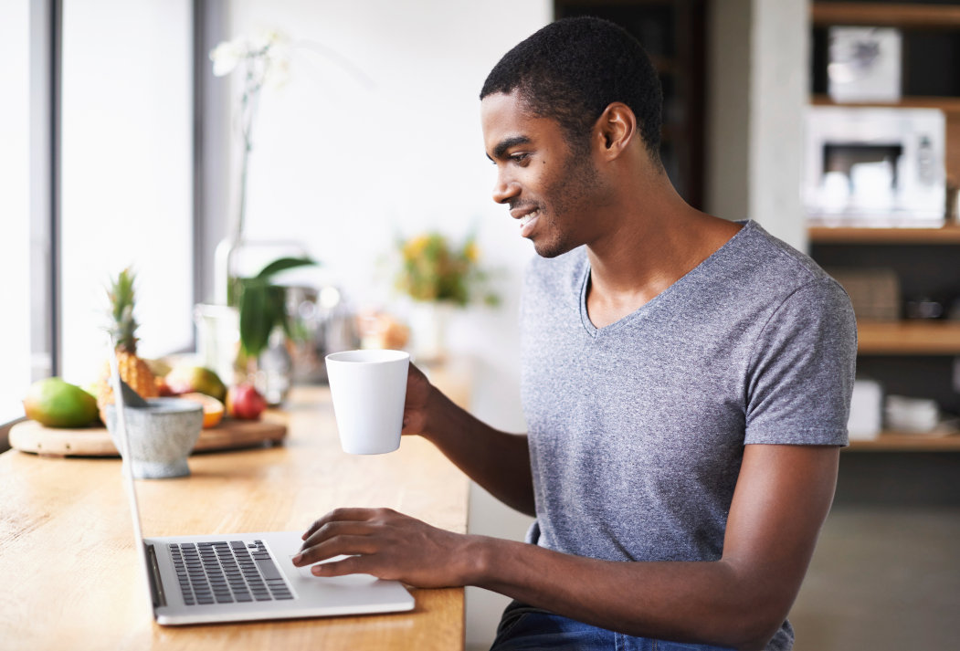 Smiling man on laptop computer shopping for renter's insurance.